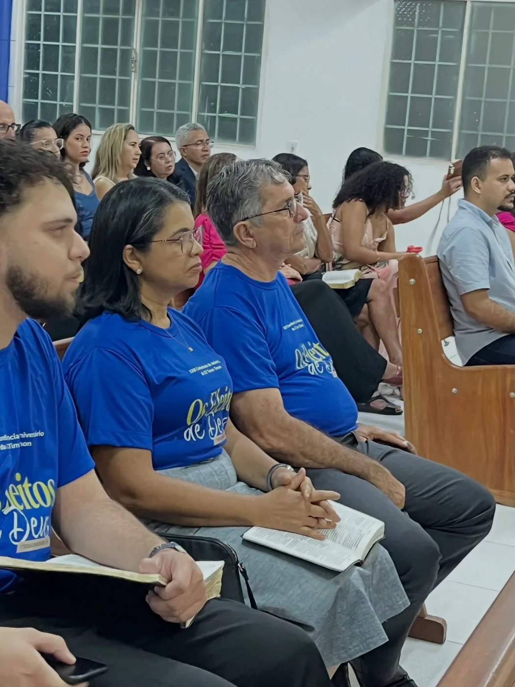 Irmãos acompanhando a conferência com a Bíblia
